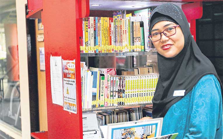 works at the mobile library kiosk of Eunos Community Club under the CDC Community Employment Programme.