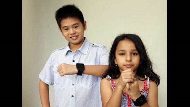  ​Ten-year-old Joshua Tham (left) and six-year-old Adira Kelath are part of a group testing a new wearable gadget for kids aged six to 12. It is meant to encourage children to spend more time outdoors, which is said to reduce the incidence of myopia.  ST Photo Chew Seng Kim