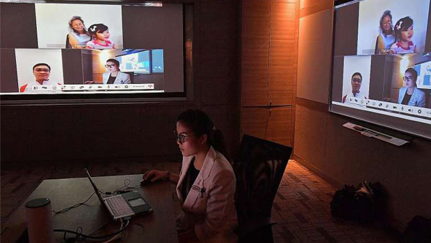  ​Clinical pharmacist Vanessa Cheong from KKH conducting a video consultation with a mock patient at home with her caregiver and the patient's "father" yesterday. Depending on the hospital, patients may pay for the video consultations upfront after their first face-to-face doctor's visit, and the costs could be lower than seeing a doctor face-to-face.  ST PHOTO DESMOND FOO