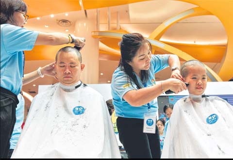  Mr Ken Lim and his son Javier having their heads shaved for Hair for Hope in July. This is Javier's 10th time participating in the event to show support for cancer patients. His selflessness and positive outlook on life won him a Singapore Health Inspirational Patient Award given out by SingHealth this year. ST PHOTO LEE JIA WEN  